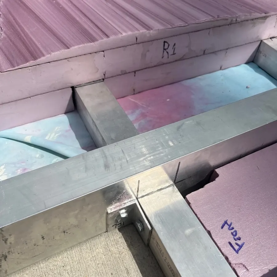Close-up of foam built up around the aluminum frame joint.