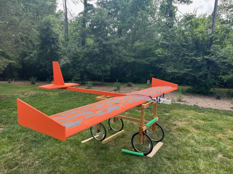 Fully painted orange and black tiger-striped glider on a lawn.