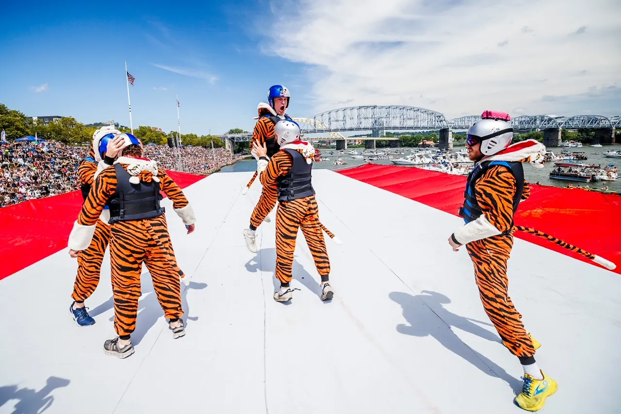 Team members in tiger costumes hyping up the crowd on the flight deck.