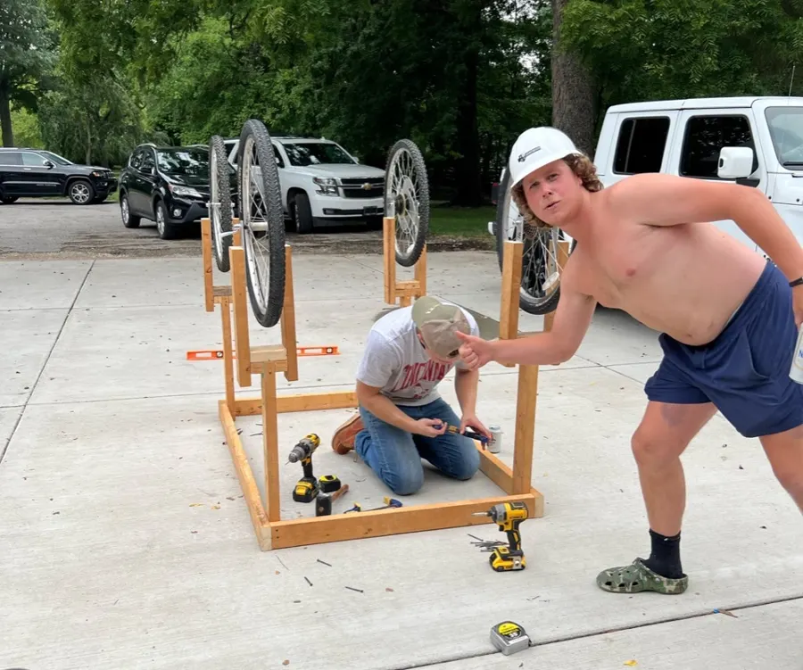 Scott and a teammate building the wooden cart frame with bike wheels.