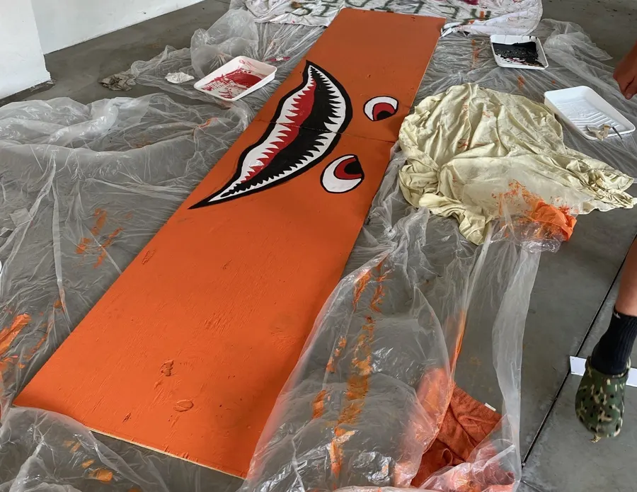 Painted cart side panels laid out on the ground.