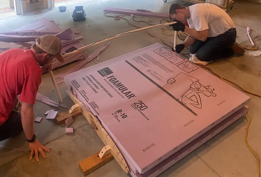 Team member tracing the hot wire around the airfoil jig on a foam block.